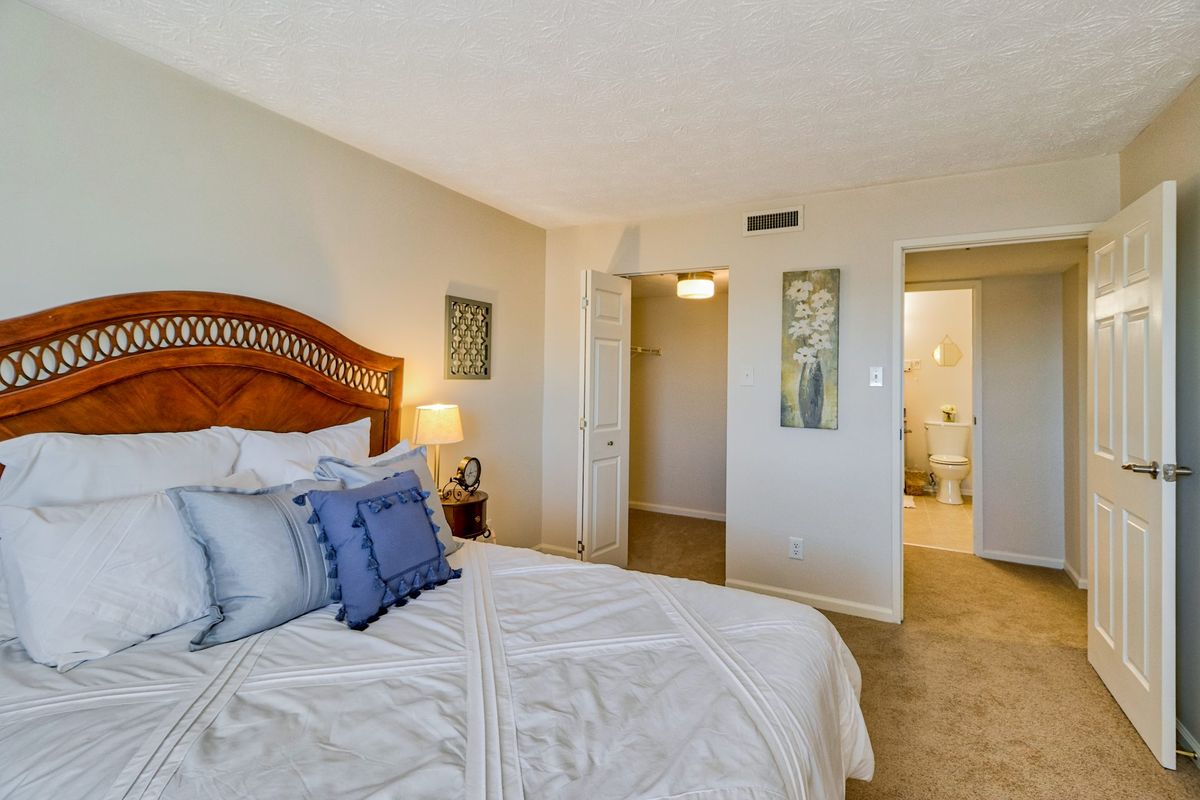 A cozy bedroom with a neatly made bed, soft lighting, and tasteful decor.