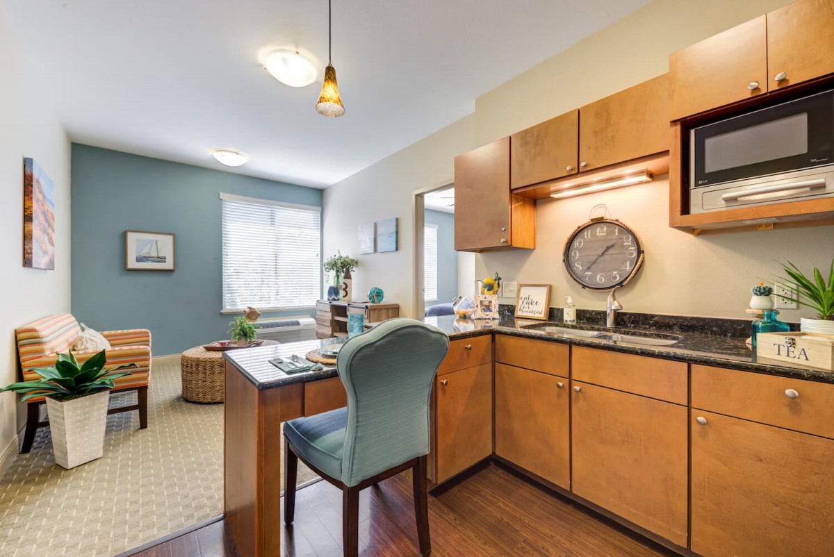 A modern apartment kitchen with a small dining area.