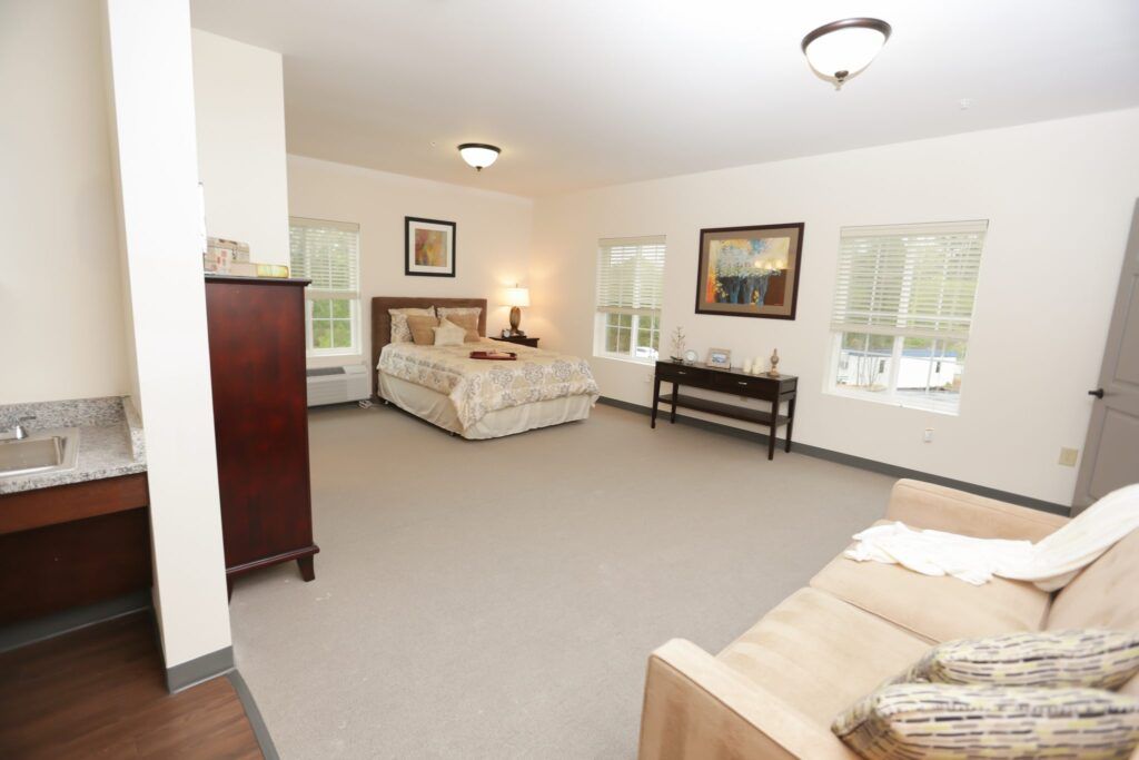 A spacious bedroom with elegant furniture and large windows.
