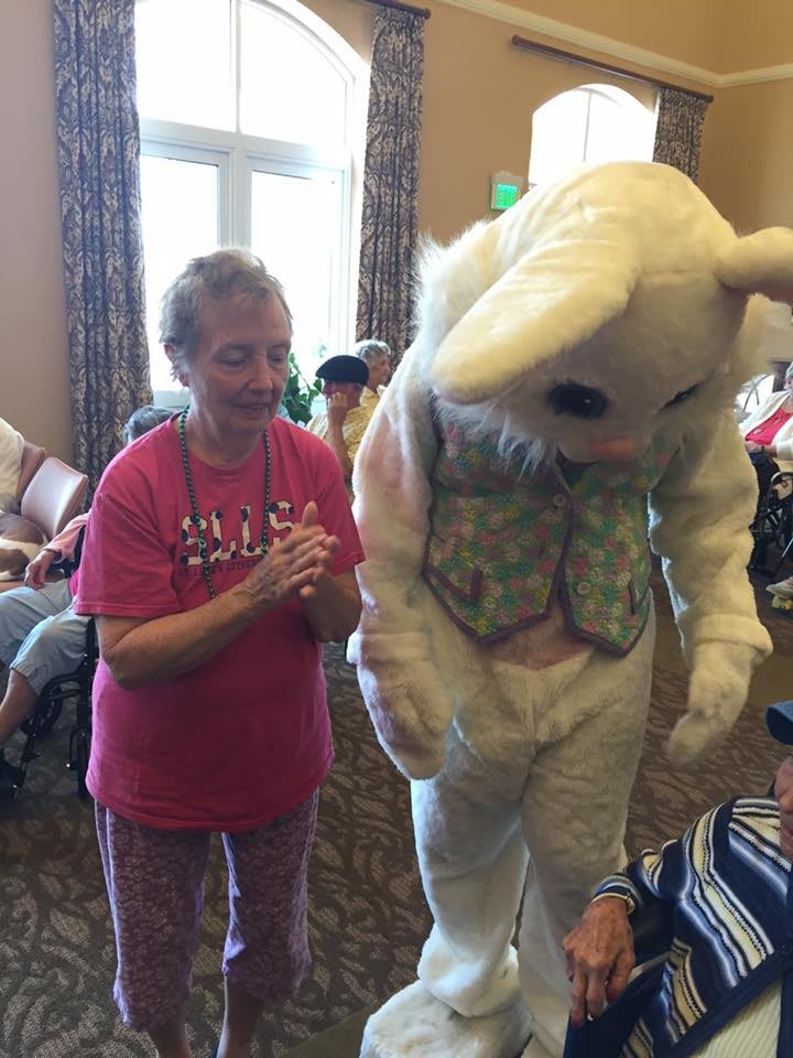 A person enjoying time with a costumed Easter bunny indoors.