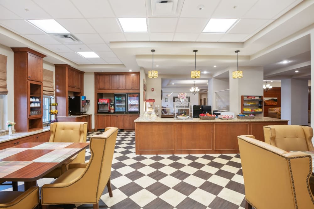 A bright and spacious dining area with a checkered floor and wooden furniture.