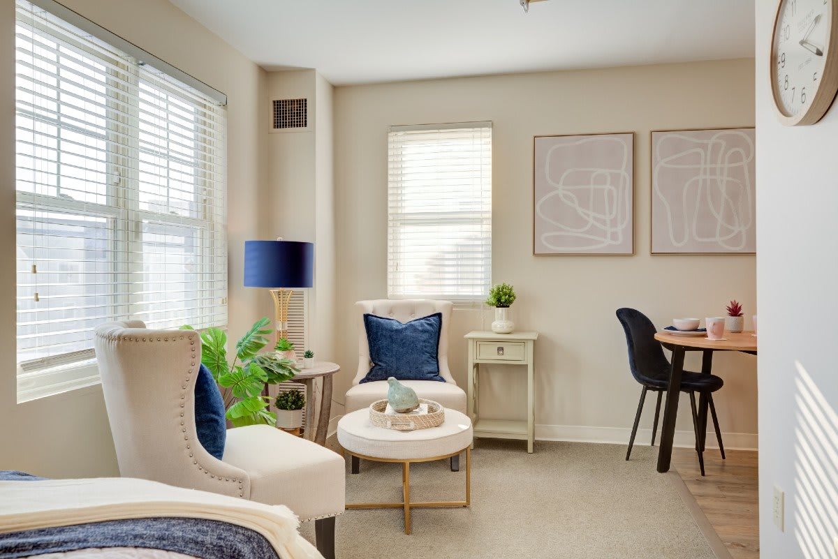 A beautifully designed living room with modern decor, featuring comfortable seating and blue accents, bathed in natural light.
