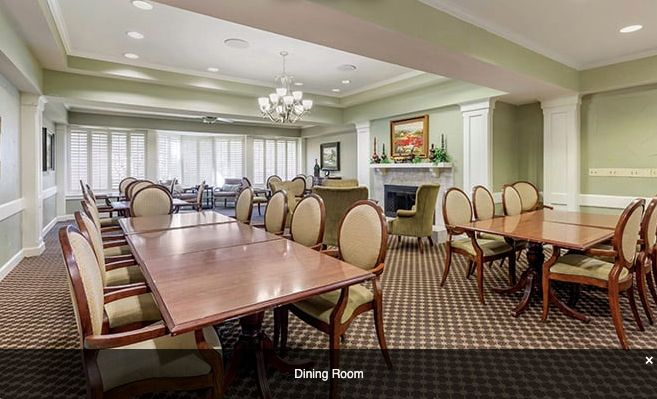 A spacious dining room with elegant furnishings and a fireplace.