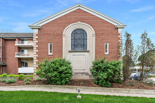 A charming brick building featuring an elegant entrance and well-maintained landscaping.