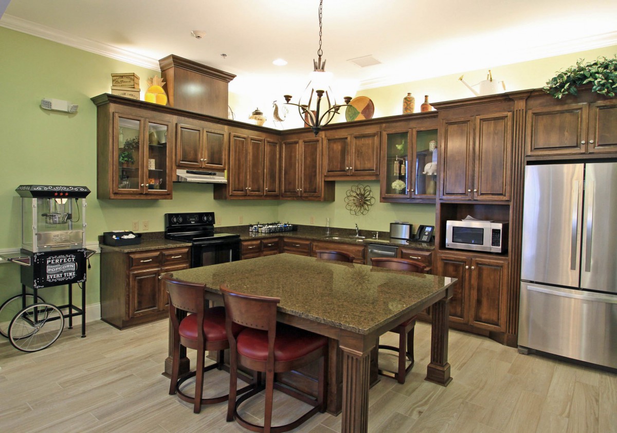 A spacious kitchen with wooden cabinets, a central island, and various appliances.