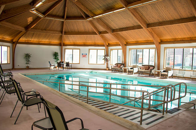 A serene indoor pool area with ample seating and natural light streaming through large windows.