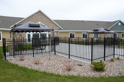 A view of a fenced patio area with a gazebo, adjacent to a residential building.