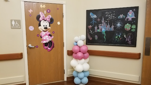 A cheerful entrance decorated for a children's party with Minnie Mouse and colorful balloons.