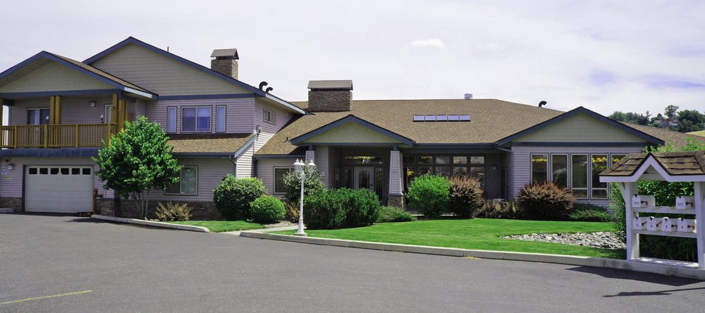 A suburban house with a well-maintained lawn and shrubs.