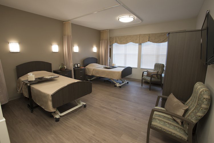 A modern hospital room with two beds, equipped for patient care.
