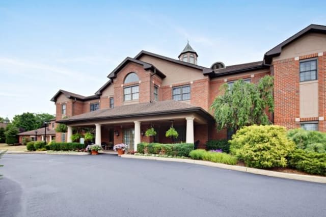 A brick building with a landscaped entrance and driveway.