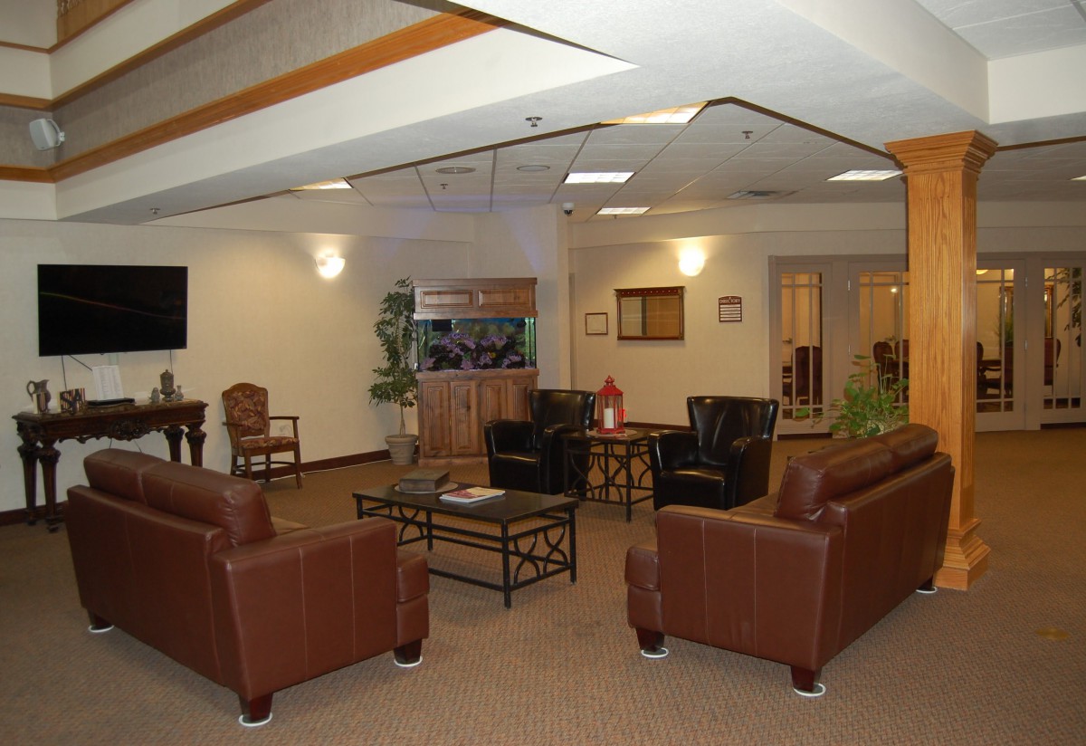A comfortable lounge area with brown leather sofas and chairs, featuring a central coffee table and ambient lighting.