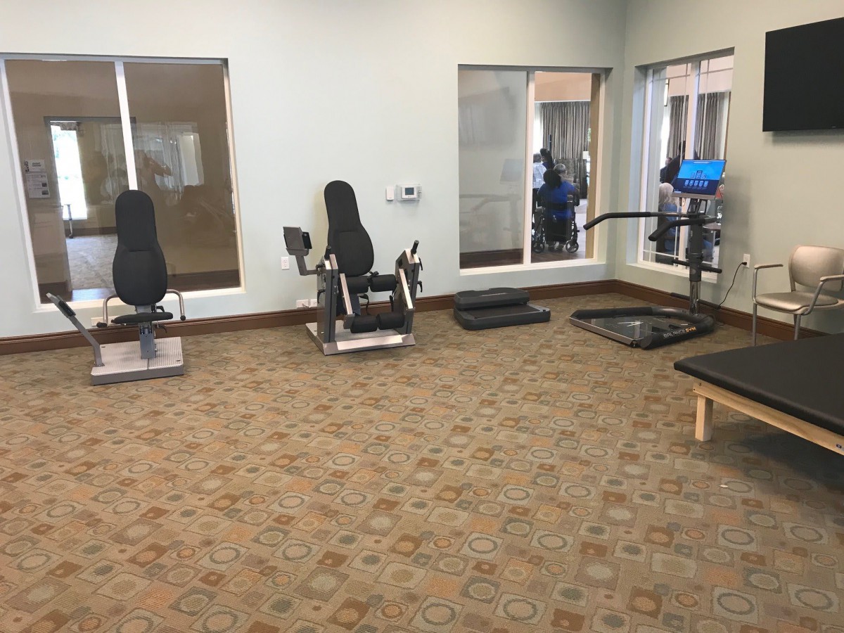 A view of an indoor gym with various exercise equipment.