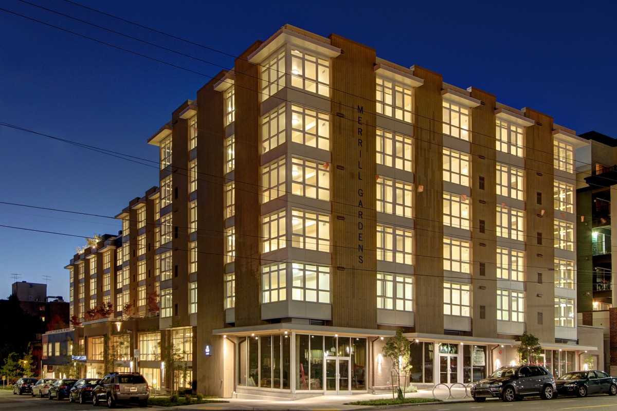 A modern apartment building illuminated at night, showcasing its architectural design.