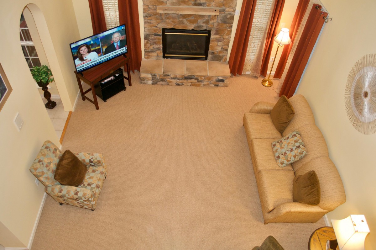 A cozy living room with a fireplace, sofas, and a television.