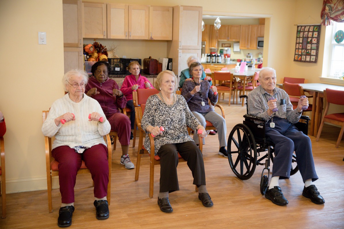 A group of seniors engaging in a seated exercise session at a community center.
