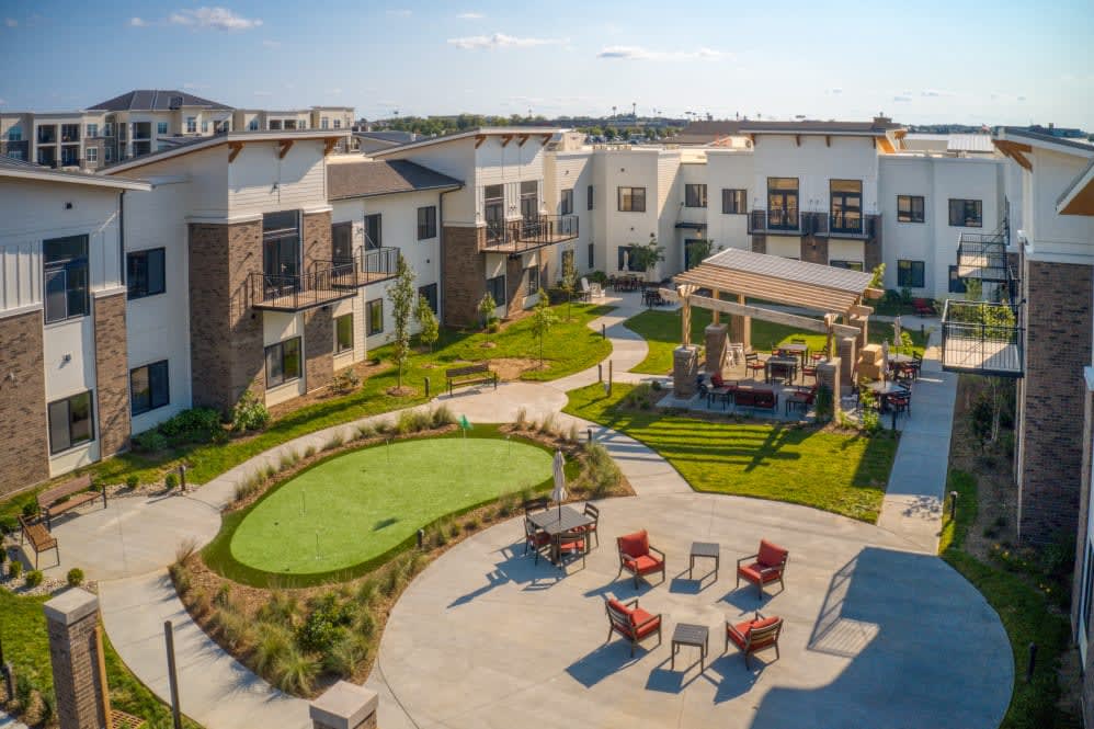 A modern residential complex with outdoor seating and landscaped gardens.
