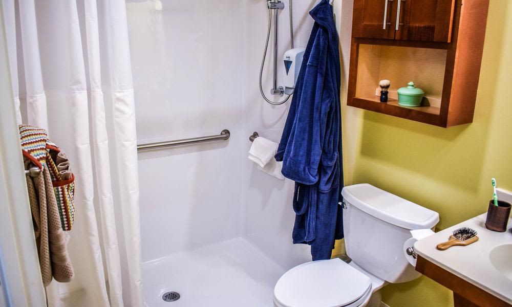 A modern bathroom with a shower area, towel rail, and toilet.