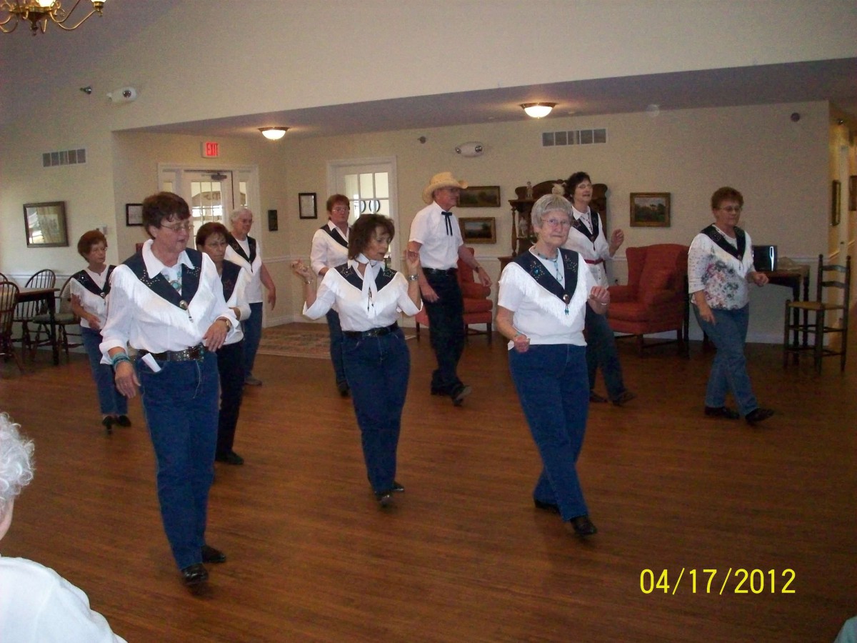 A group of people participating in a line dancing class indoors.