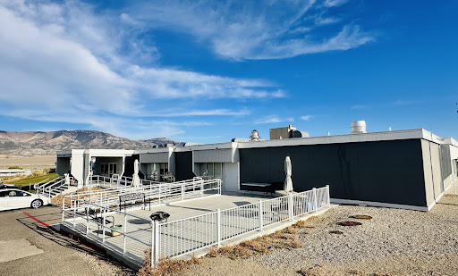 A modern building featuring a fenced outdoor area under a clear blue sky.