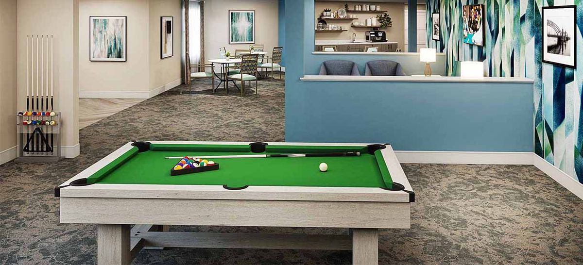 A modern game room featuring a pool table and a comfortable seating area.