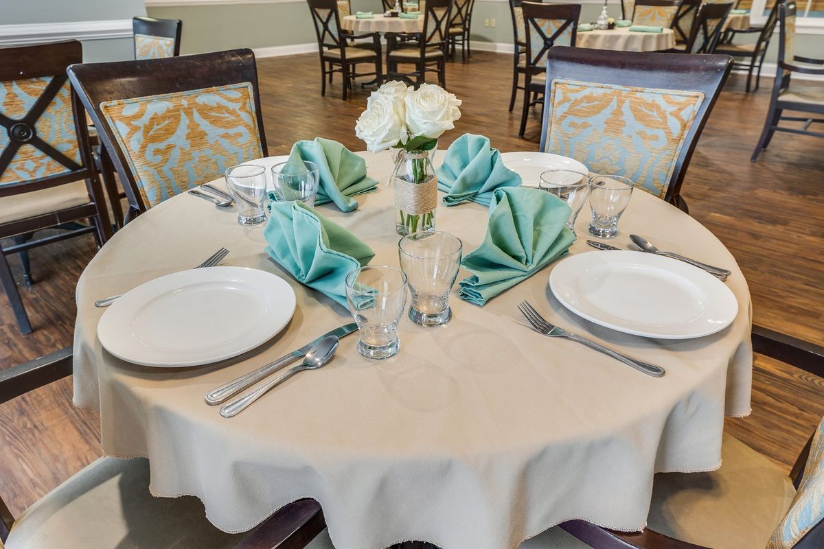 A beautifully set dining table with teal napkins and elegant centerpieces.
