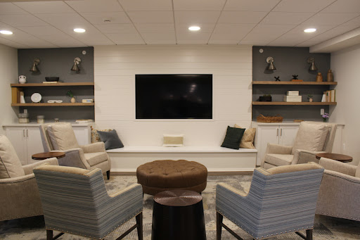 A modern living room setup featuring comfortable seating, a television, and stylish shelves.