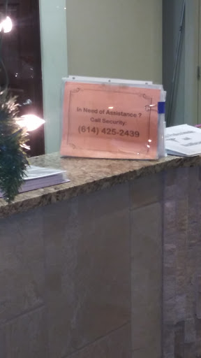 A sign at a reception desk providing contact information.