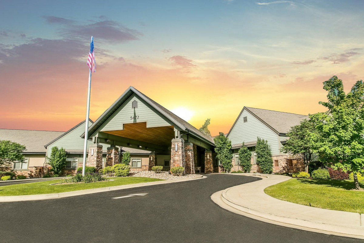 A beautiful church building with a flagpole at sunset.