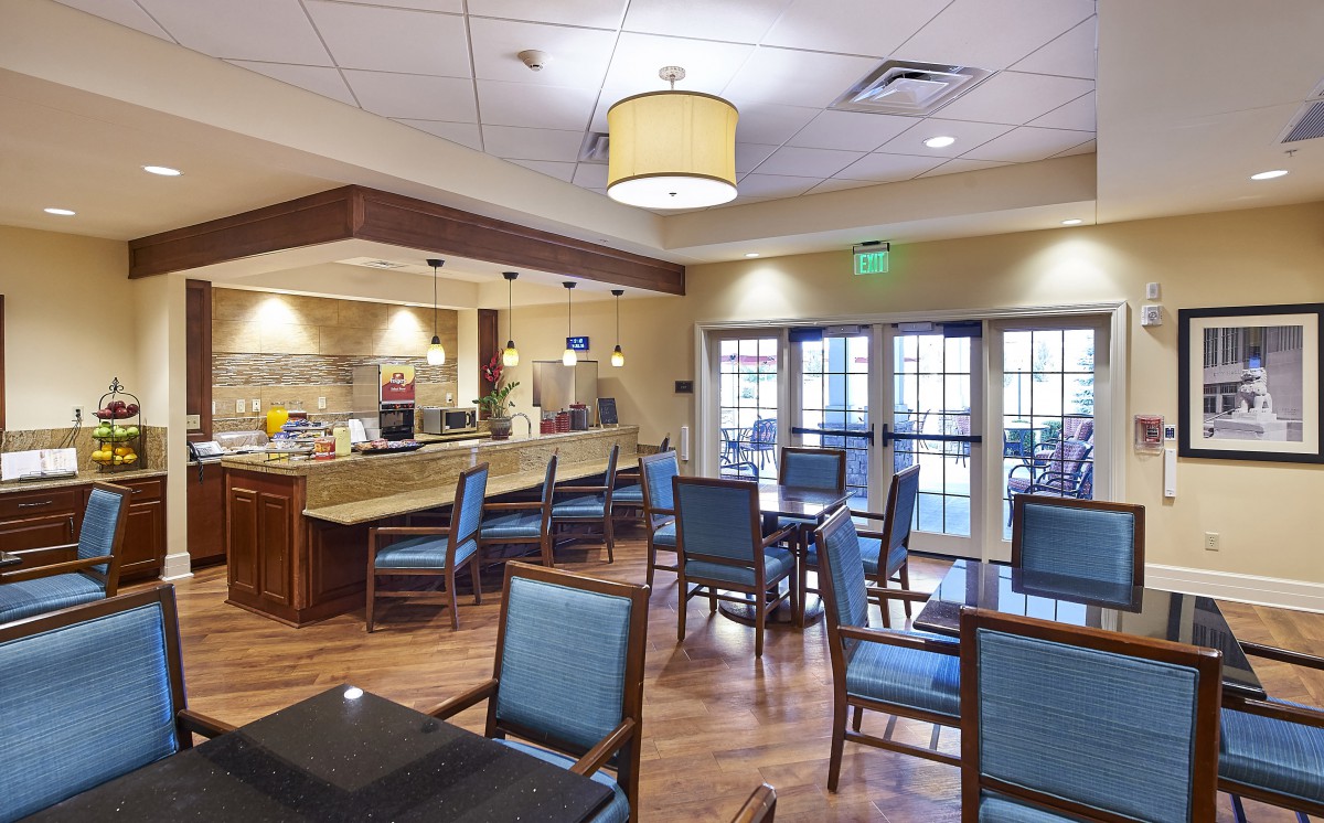 A well-lit dining area with tables, chairs, and a bar counter.