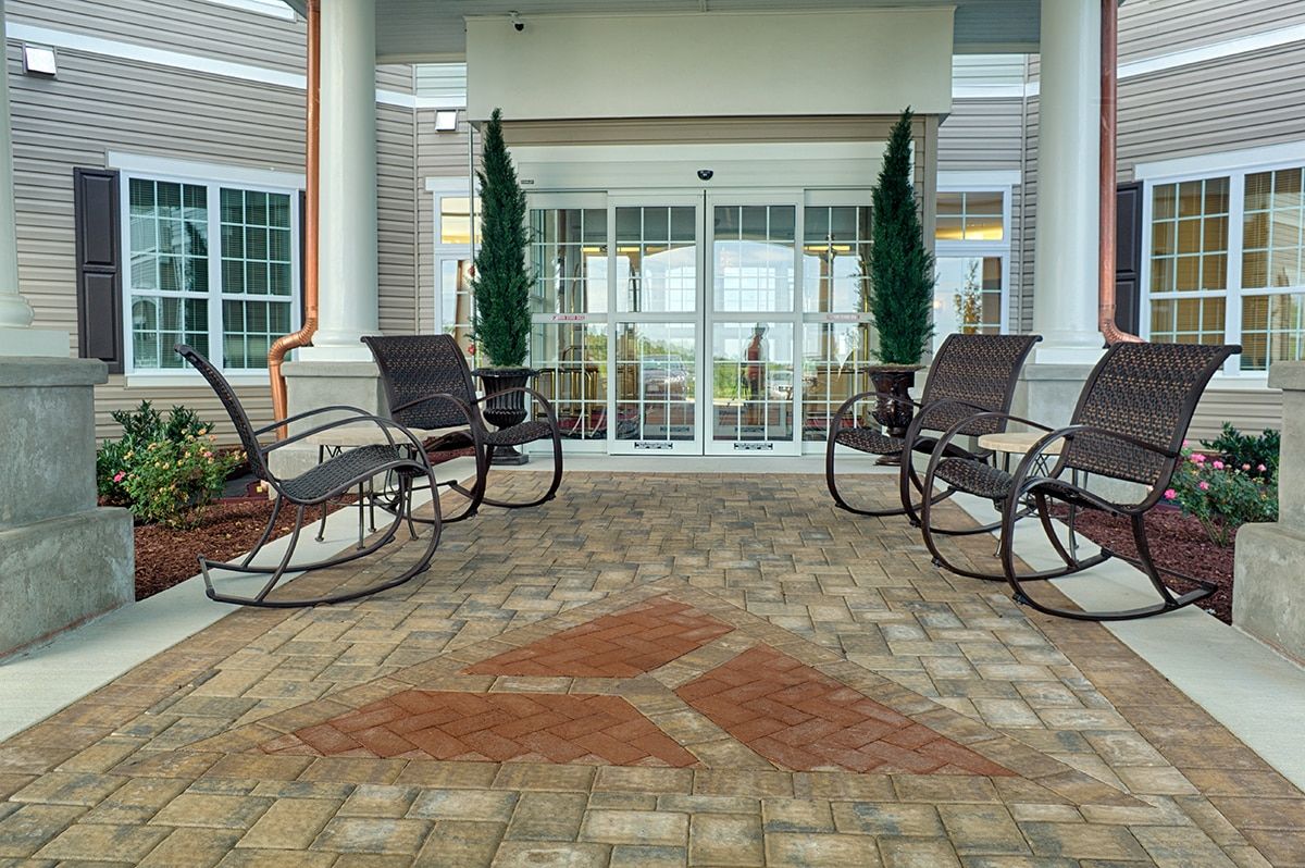 A welcoming porch area with rocking chairs and potted plants.