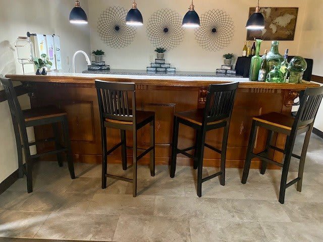 A cozy kitchen bar with wooden stools and pendant lighting.