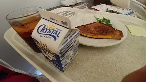 A simple breakfast featuring a grilled cheese sandwich, an omelette, and a carton of milk.
