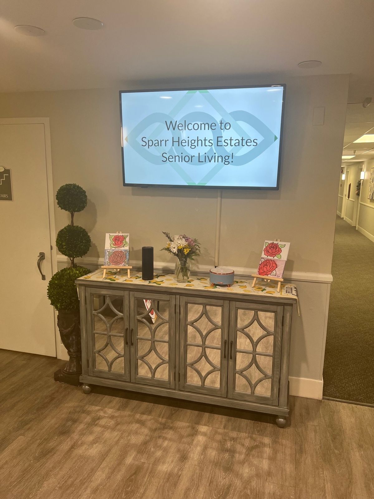 A welcoming interior hallway display featuring a welcome sign above a decorated console table.