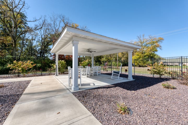 A cozy outdoor gazebo with seating under a clear blue sky.