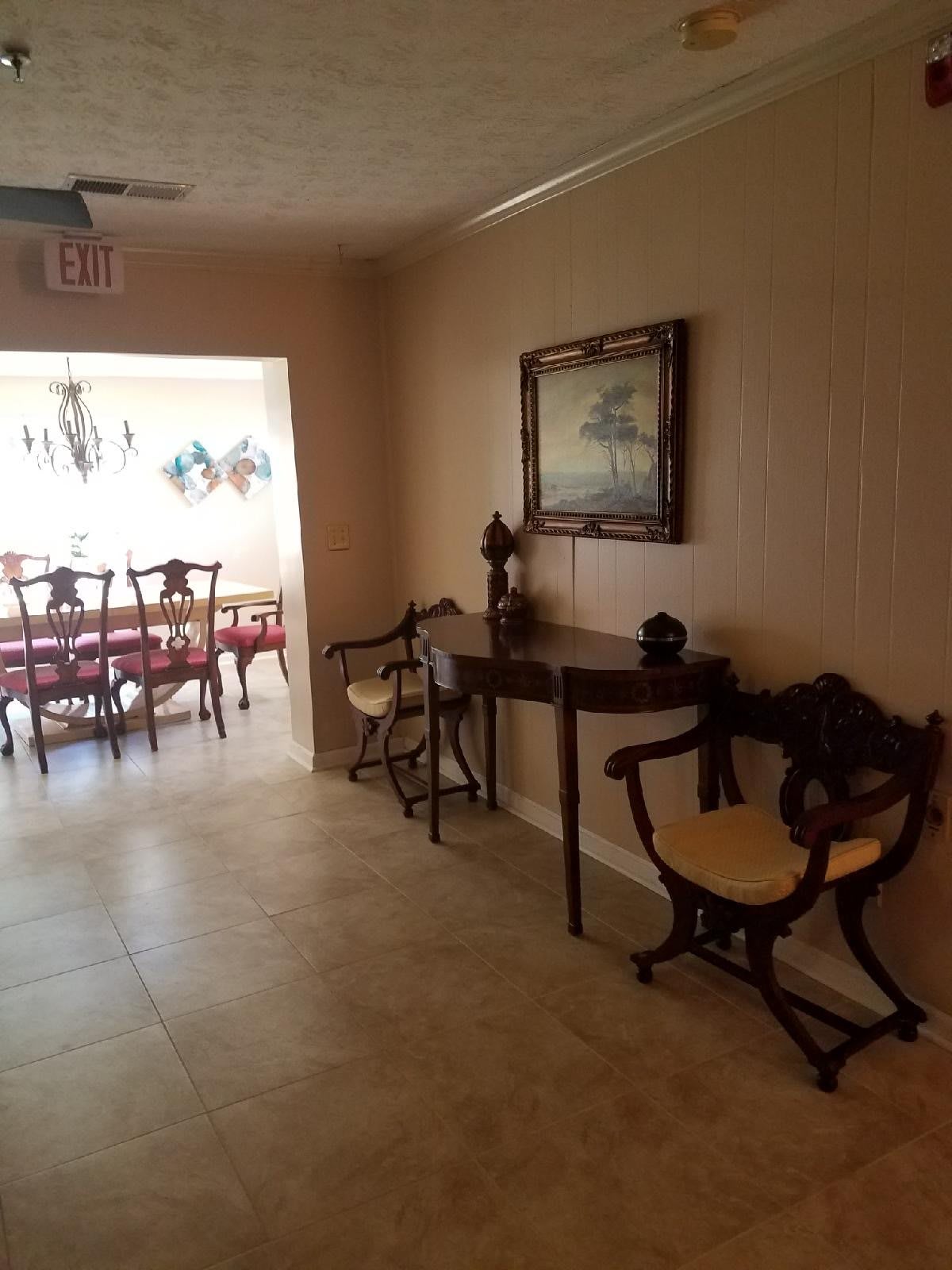 A hallway with elegant furniture leading to a dining area.