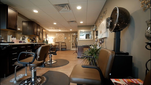 A cozy and modern hair salon interior featuring a waiting area and styling chairs.