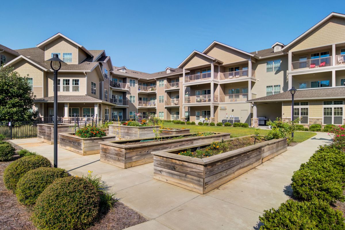 A modern apartment complex with landscaped gardens and balconies.