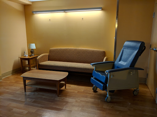 A cozy waiting area featuring a sofa, a chair, and a table.
