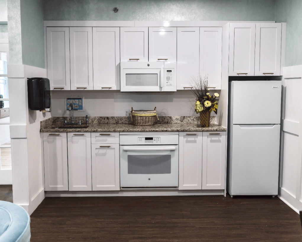A modern kitchen with white cabinets and appliances.