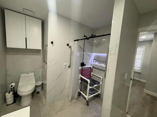 A modern bathroom featuring essential amenities and a medical equipment setup.