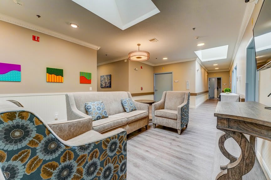 A modern and bright lobby area with comfortable seating and artwork on the walls.