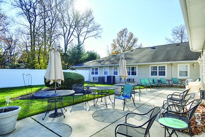 A sunny patio with outdoor seating, tables, and umbrellas.
