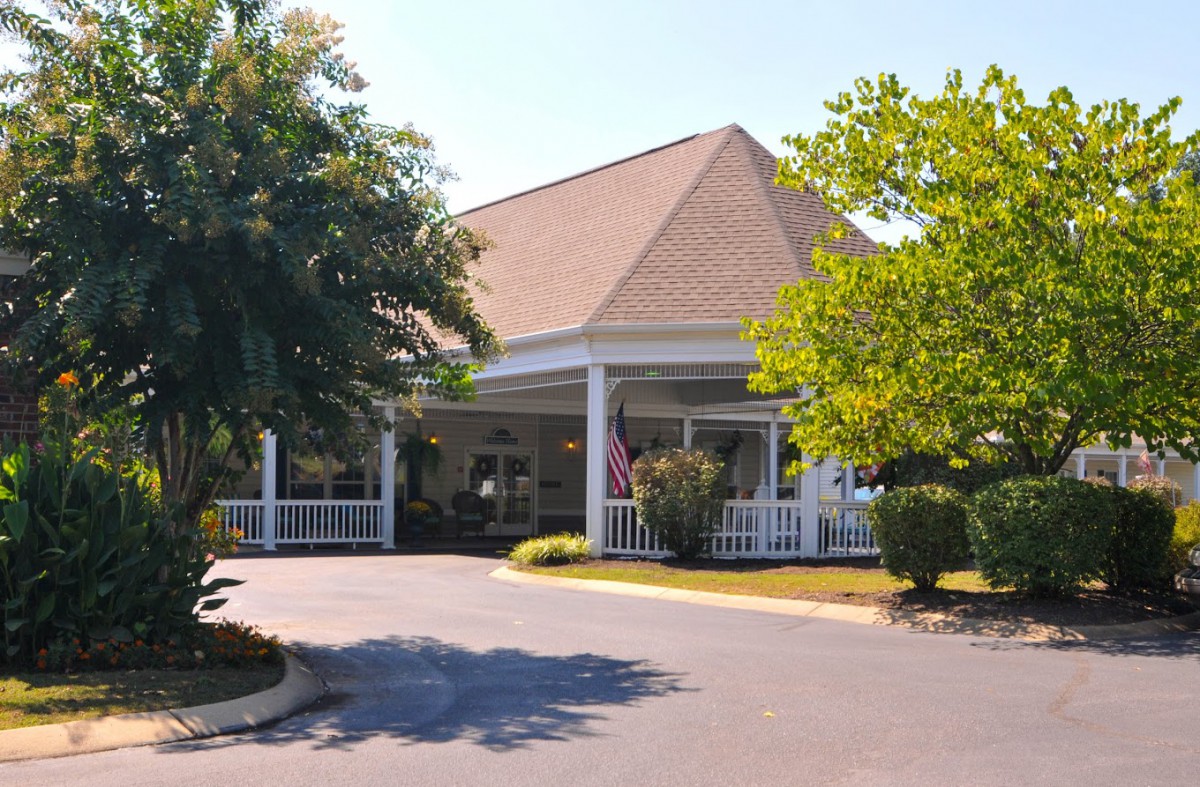 Front view of a building with a landscaped entrance and driveway.