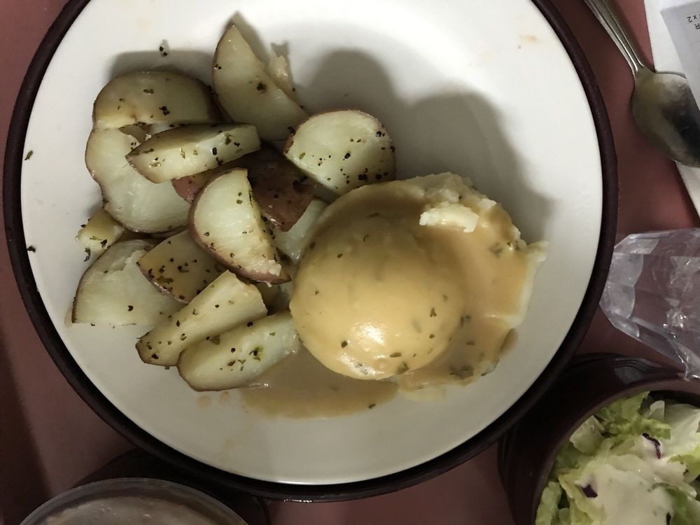 A plate of sliced potatoes with gravy.