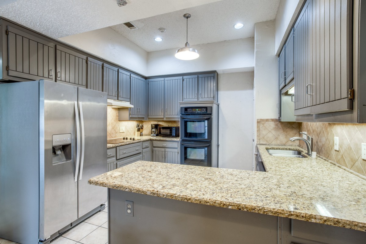 A modern kitchen with stainless steel appliances and granite countertops.