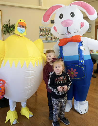 A joyful Easter celebration with children posing alongside inflatable characters.