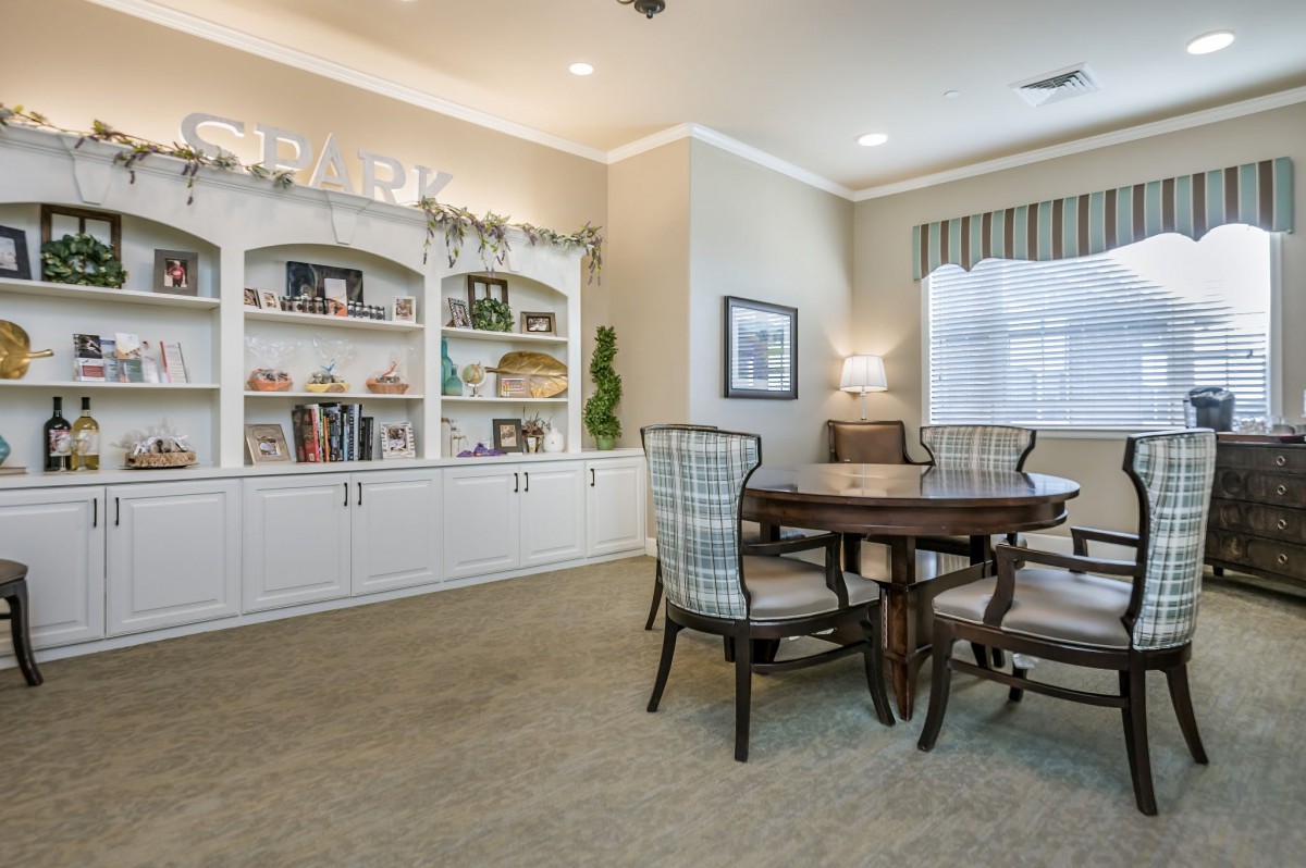 A cozy living room with built-in bookshelves and a round table with chairs.