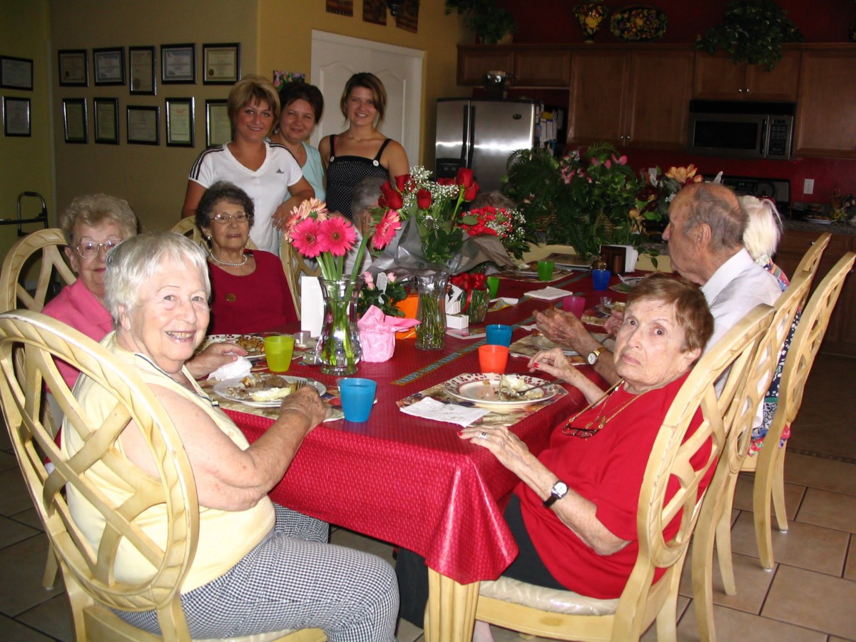A group of people enjoying a meal together around a decorated dinner table.