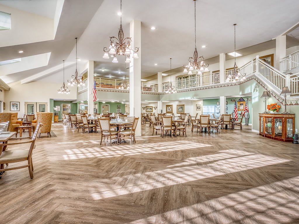 A spacious and modern dining area with elegant chandeliers and ample seating.